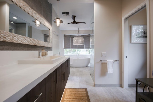 bathroom featuring ceiling fan, vanity, and a bathtub