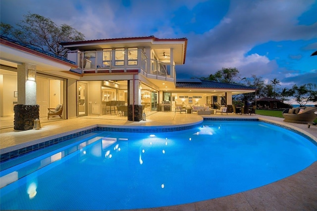 pool at dusk with a patio area