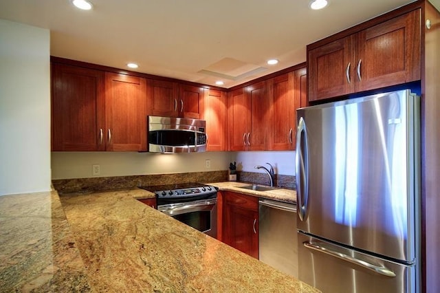 kitchen featuring light stone countertops, appliances with stainless steel finishes, and sink