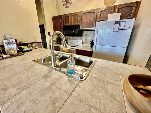 kitchen featuring sink, white appliances, and decorative backsplash