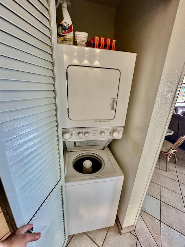 clothes washing area featuring stacked washer / dryer and light tile patterned floors