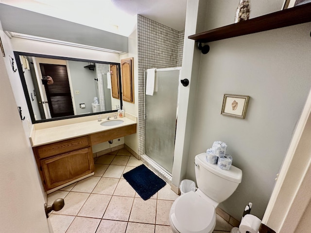 bathroom featuring tile patterned flooring, vanity, a shower with door, and toilet