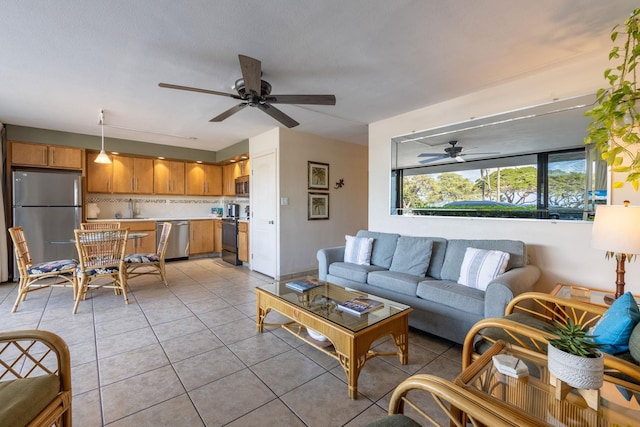 living room featuring light tile patterned flooring, ceiling fan, and sink