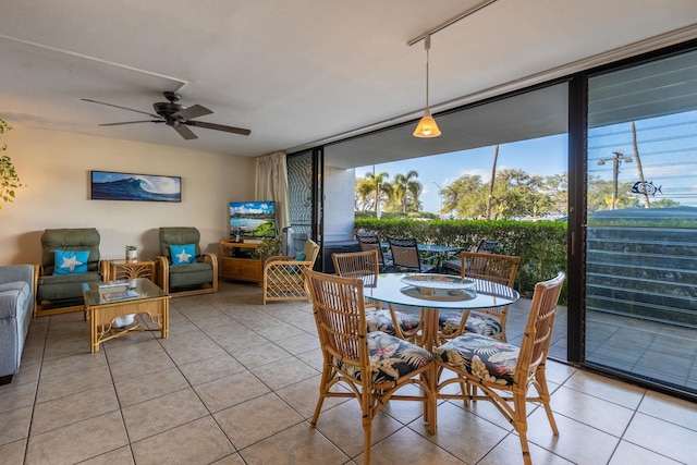 tiled dining room with a wealth of natural light, ceiling fan, and floor to ceiling windows