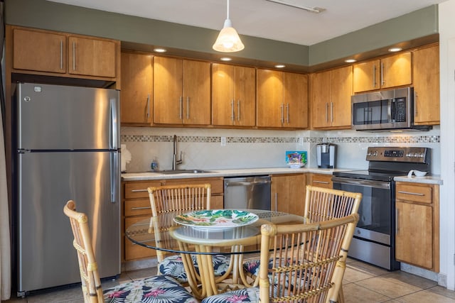 kitchen with stainless steel appliances, decorative backsplash, sink, light tile patterned flooring, and pendant lighting