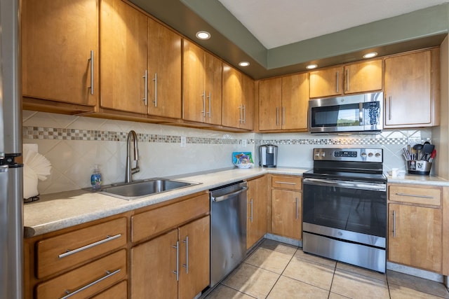 kitchen featuring light tile patterned floors, sink, backsplash, and appliances with stainless steel finishes