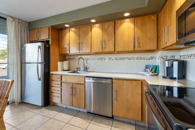 kitchen with decorative backsplash, appliances with stainless steel finishes, sink, and light tile patterned floors