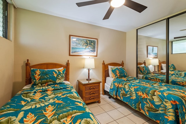 bedroom with a closet, light tile patterned flooring, and ceiling fan