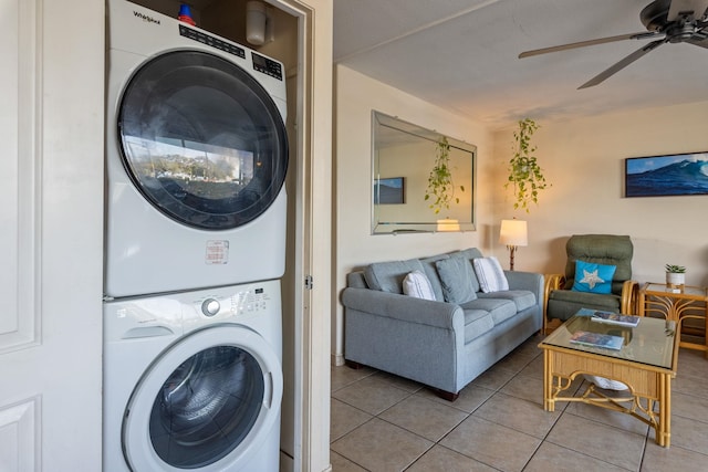 clothes washing area featuring stacked washing maching and dryer, light tile patterned flooring, and ceiling fan