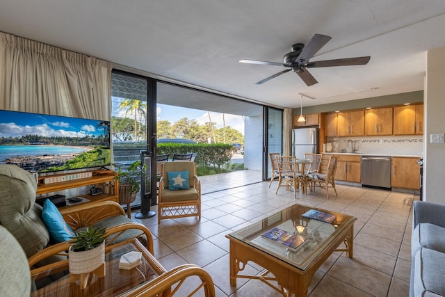 living room featuring expansive windows, sink, light tile patterned floors, and ceiling fan