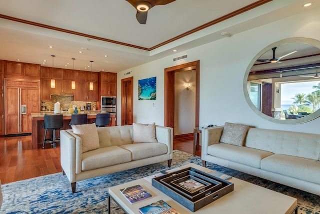 living room featuring visible vents, ceiling fan, ornamental molding, recessed lighting, and wood finished floors