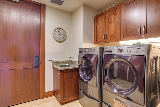 laundry area with visible vents, light tile patterned flooring, cabinet space, a sink, and washer and dryer