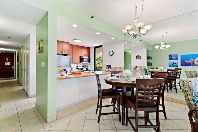 tiled dining area featuring a chandelier