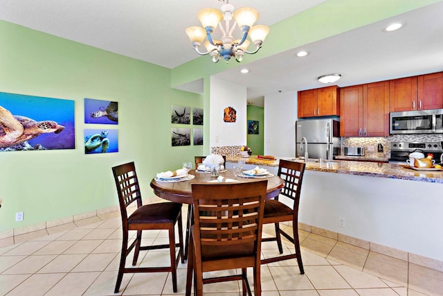 dining room featuring a notable chandelier, light tile patterned floors, and sink