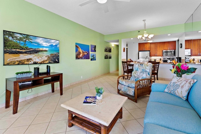 tiled living room with ceiling fan with notable chandelier