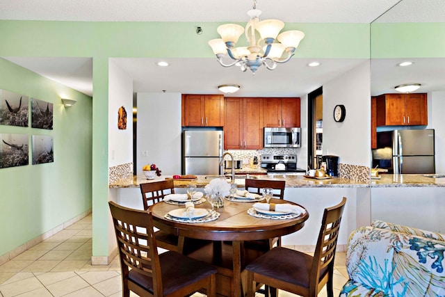 dining area featuring sink, light tile patterned floors, and a notable chandelier