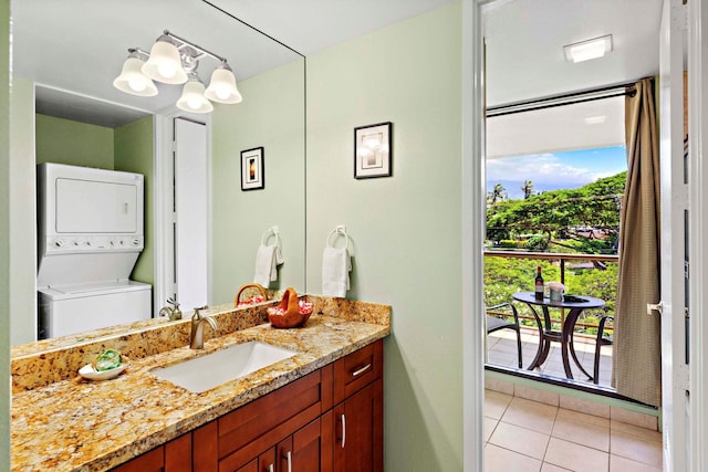 bathroom featuring tile patterned floors, a chandelier, vanity, and stacked washing maching and dryer