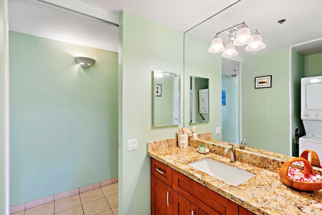 bathroom with tile patterned flooring, vanity, and stacked washer and clothes dryer