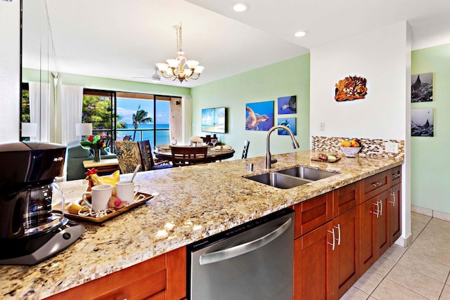 kitchen featuring dishwasher, sink, an inviting chandelier, light stone counters, and light tile patterned flooring