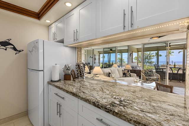 2385 S Kihei Rd Unit 306, Kihei, HI 96753 - kitchen with recessed lighting, light stone countertops, white cabinetry, open floor plan, and light tile patterned floors