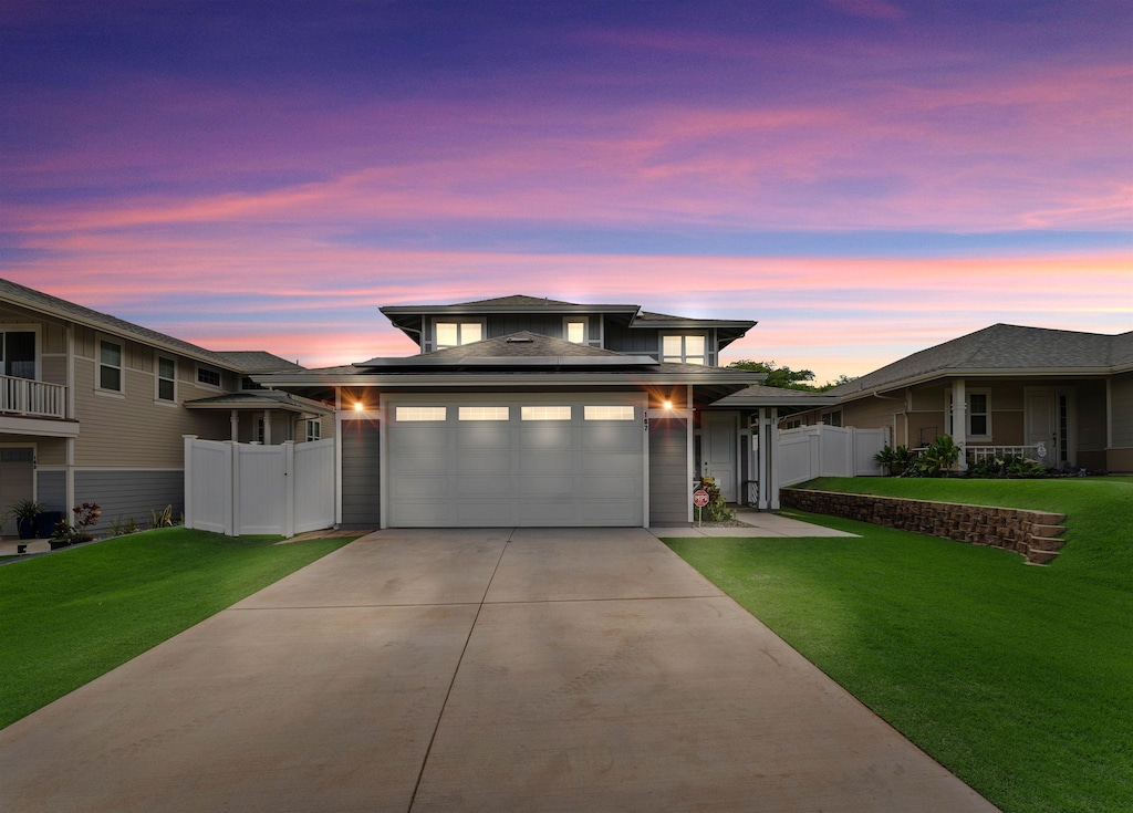 prairie-style house featuring a garage and a lawn