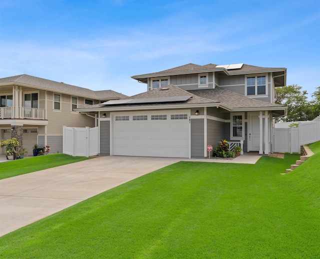 prairie-style house featuring a garage, a front yard, and solar panels