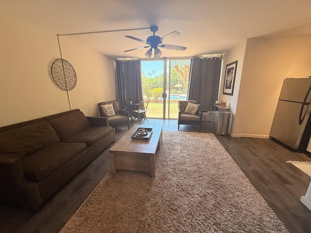 3660 Lower Honoapiilani Rd Unit 111, Lahaina, HI 96761 - living area with expansive windows, dark wood-type flooring, a ceiling fan, and baseboards