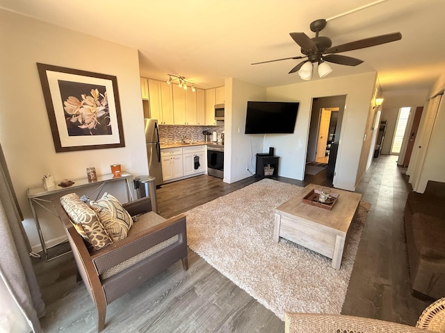 3660 Lower Honoapiilani Rd Unit 111, Lahaina, HI 96761 - living room featuring dark wood-style floors, a wood stove, and ceiling fan