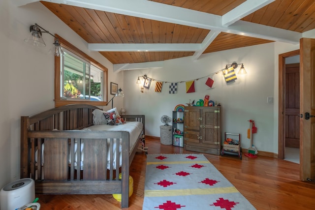 bedroom featuring baseboards, wood ceiling, wood finished floors, and beamed ceiling