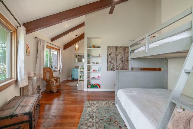 bedroom with vaulted ceiling with beams, baseboards, and wood finished floors