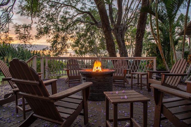 deck at dusk featuring a fire pit