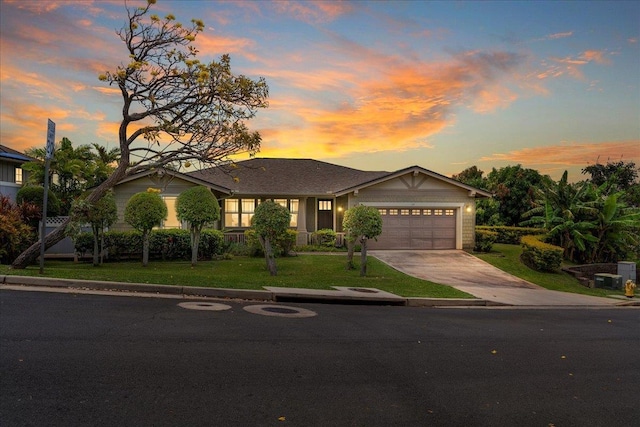 view of front of property featuring a garage, a front lawn, and driveway