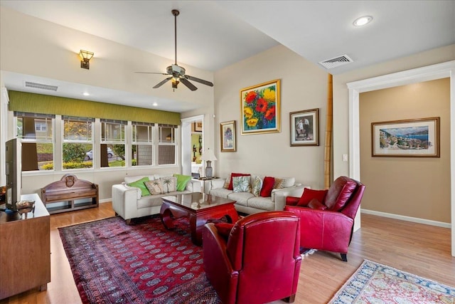 living area with visible vents, a ceiling fan, and wood finished floors