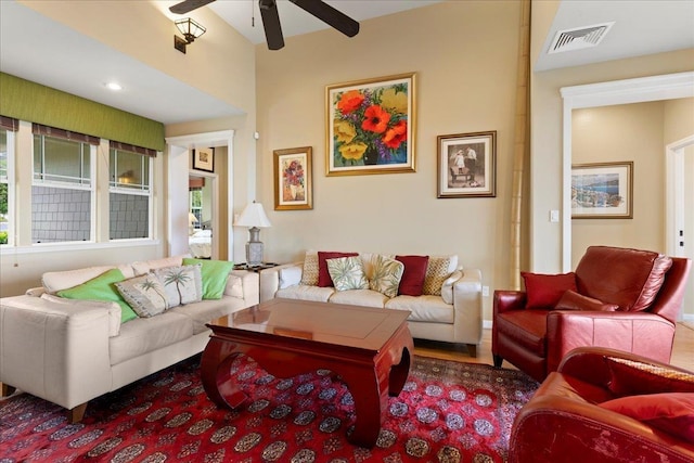 living area with a ceiling fan, visible vents, and plenty of natural light