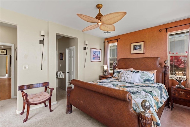 bedroom with baseboards, visible vents, ceiling fan, and light colored carpet