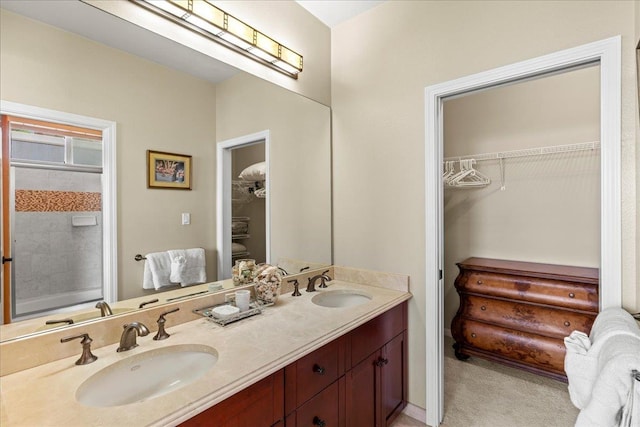 full bath featuring double vanity, a sink, and a walk in closet