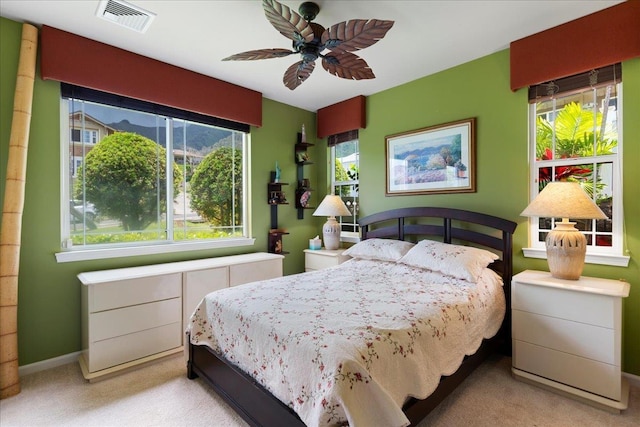 carpeted bedroom with baseboards, a ceiling fan, and visible vents