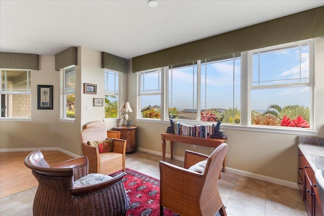 sitting room with baseboards and light tile patterned floors