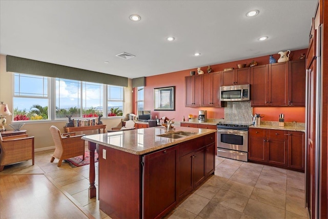 kitchen with visible vents, a sink, light stone counters, stainless steel appliances, and recessed lighting