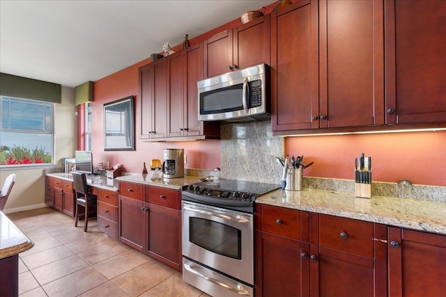 kitchen featuring appliances with stainless steel finishes, backsplash, light stone countertops, and light tile patterned floors