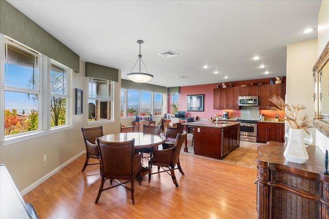 dining room with light wood-style floors, baseboards, recessed lighting, and visible vents