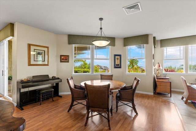 dining space with visible vents, wood finished floors, and a healthy amount of sunlight