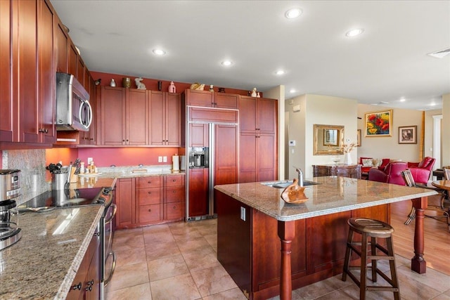 kitchen featuring a kitchen breakfast bar, visible vents, a sink, stainless steel appliances, and recessed lighting