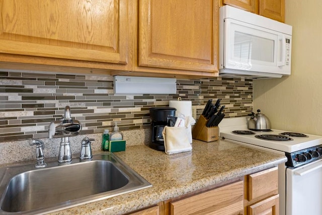 kitchen featuring light stone countertops, sink, tasteful backsplash, and white appliances