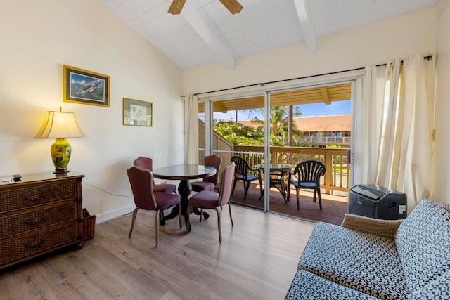 dining room featuring ceiling fan, light hardwood / wood-style floors, and lofted ceiling with beams