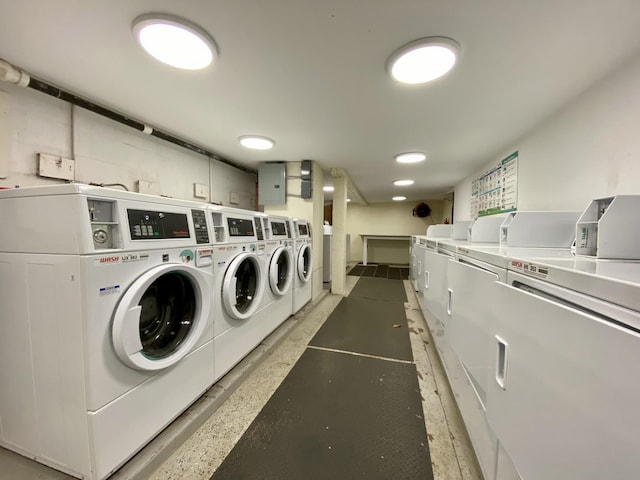 clothes washing area with washing machine and clothes dryer and electric panel