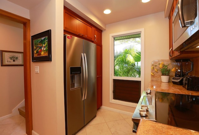 kitchen featuring light tile patterned flooring, baseboards, light countertops, and stainless steel fridge with ice dispenser