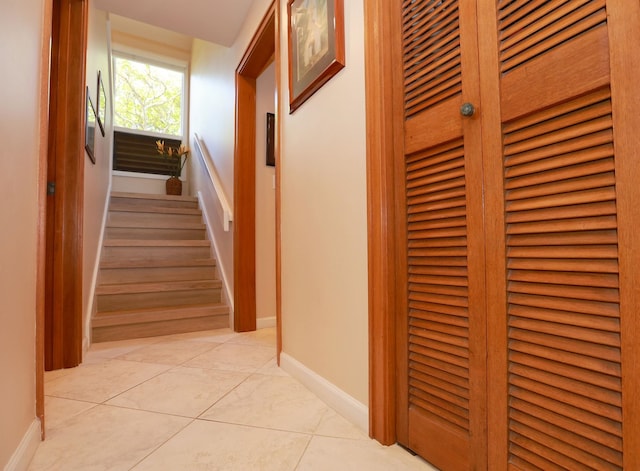 corridor with baseboards and light tile patterned floors