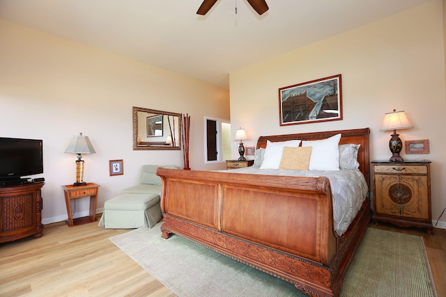 bedroom featuring light wood finished floors, a ceiling fan, and baseboards