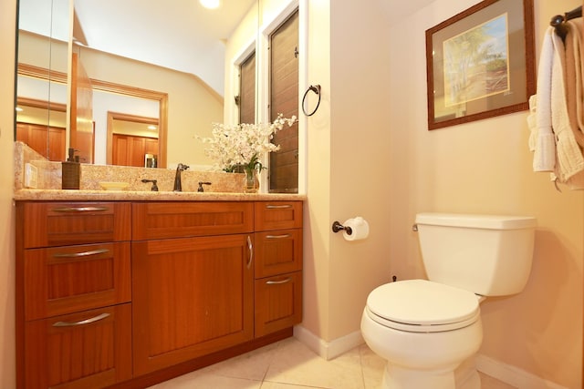 bathroom with toilet, tile patterned flooring, vanity, and baseboards